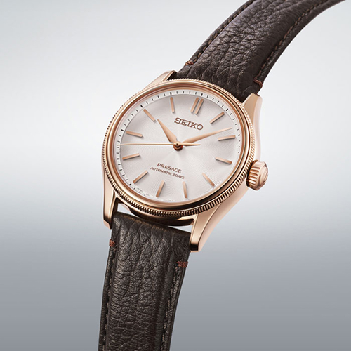 The strap is crafted from dark brown leather inspired by the elegant brick façade of the Tomioka Silk Mill