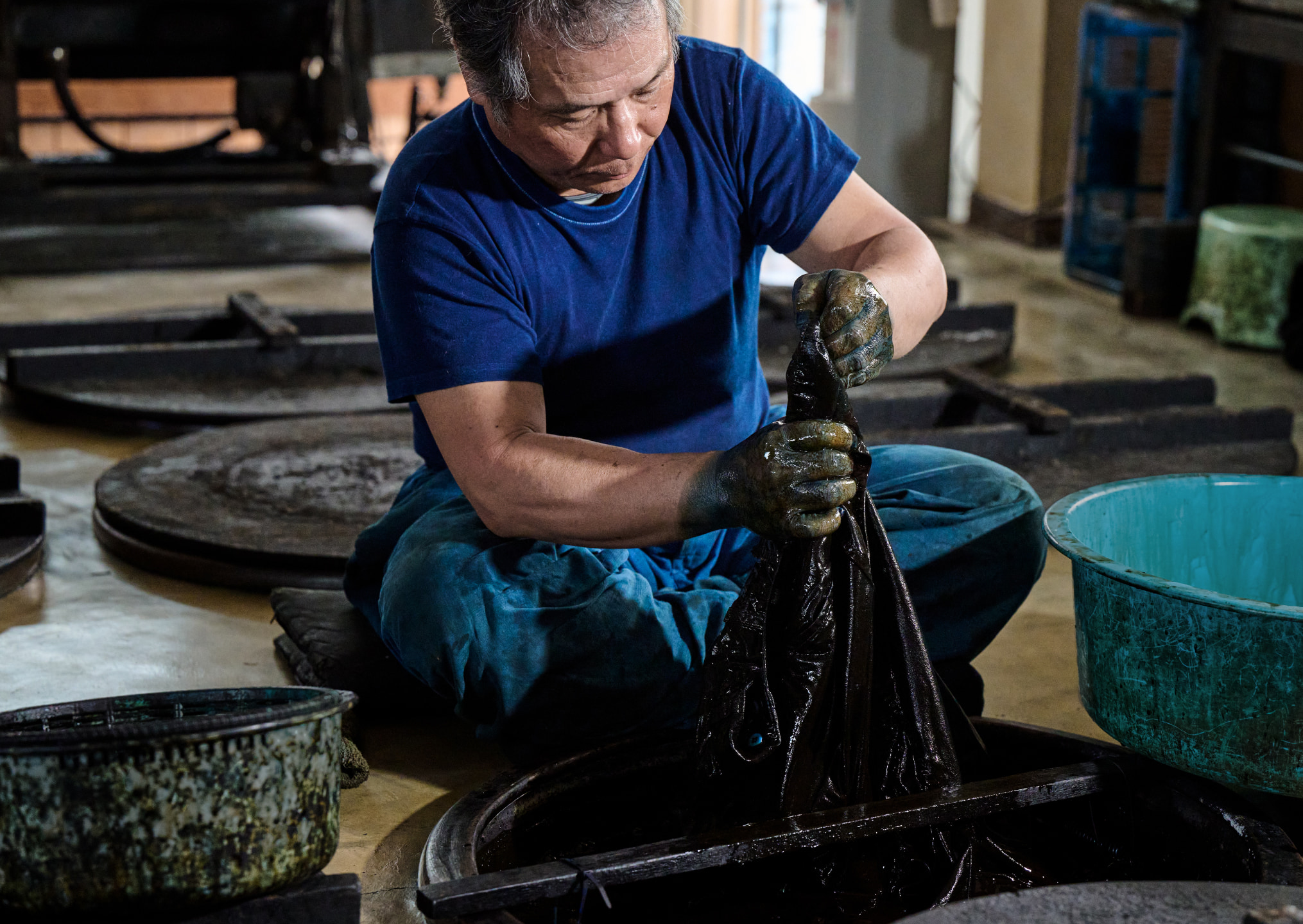 Photo of Fabric is immersed in the indigo dye for several minutes