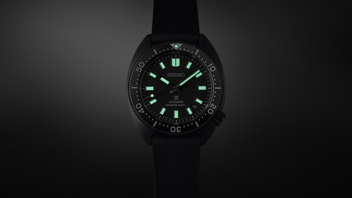 Foto do relógio de mergulho Seiko Prospex SPB335J1, onde é possível ver como a tinta luminescente Green Lumibrite Pro da Seiko é intensa mas suave para os olhos, em contraste com o mostrador preto.