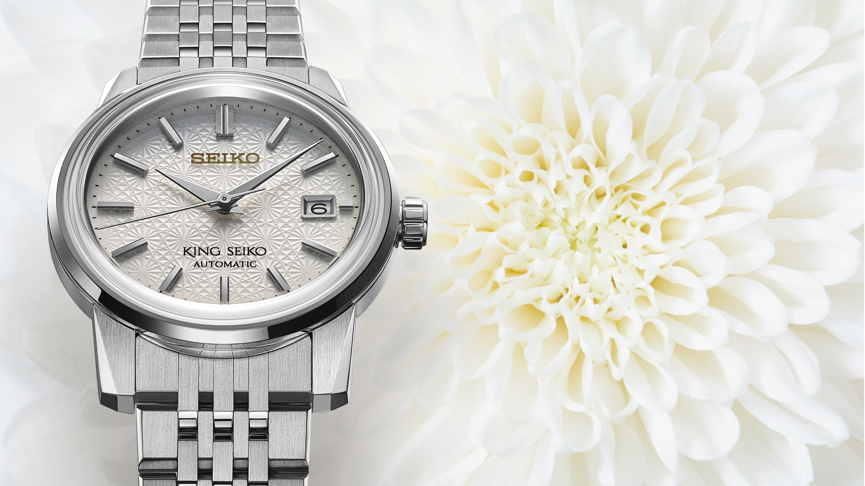 Relógio mecânico King Seiko prateado com mostrador branco com padrão crisântemo.