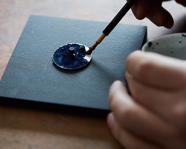 Perícia Artesanal Presage: aplicação manual do esmalte Shippo sobre um mostrador de relógio.