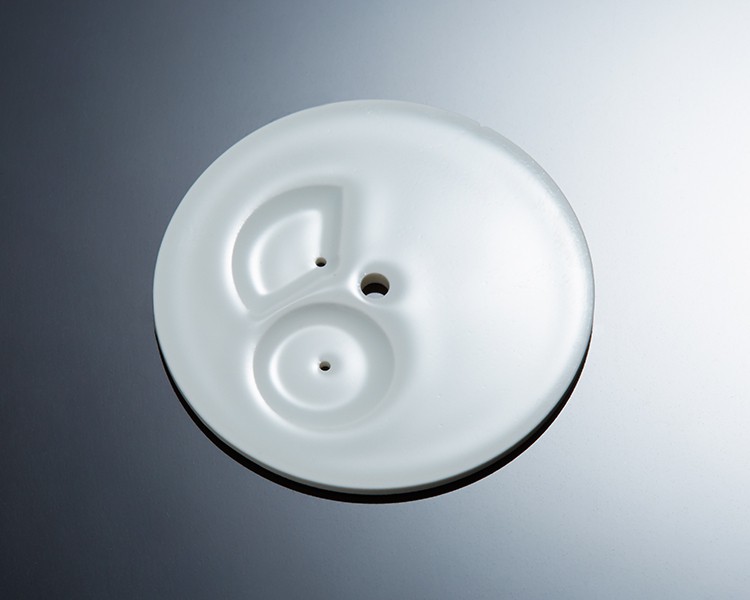 Perícia Artesanal Japonesa: detalhe de um mostrador em porcelana de Arita, com um acabamento branco suavemente brilhante.