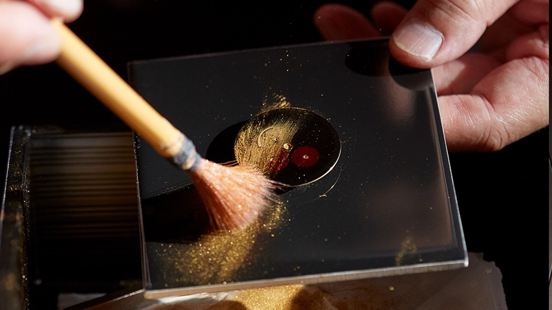 Perícia Artesanal Presage: aplicação de fino pó dourado sobre o mostrador Urushi com a técnica Maki-e.
