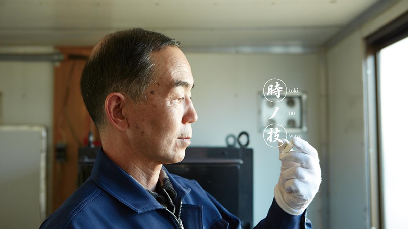 O mestre-artesão do esmalte, Mitsuru Yokosawa, verifica atentamente a placa de um mostrador Presage.